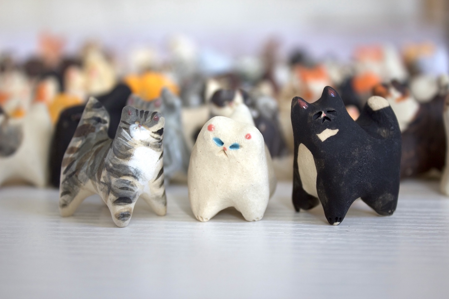 A collection of handmade ceramic cat sculptures